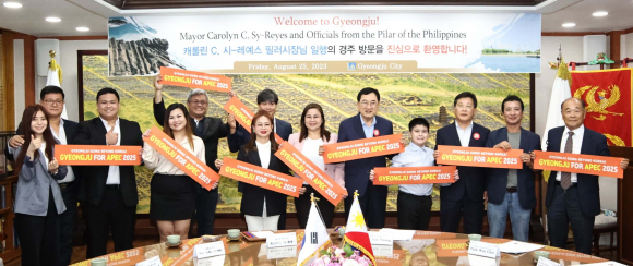 8월 25일 경주시를 방문한 필리핀 필러시 대표단이 주낙영 시장을 접견한 직후 ‘2025 APEC 정상회의 경주 유치 손 푯말’을 들고 기념촬영을 하고 있다.