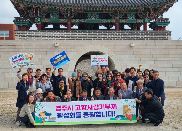 재경회동향우회 회원이 27일 경주 읍성 앞에서 경주 고향사랑 기부제를 응원하며 기념촬영을 하고 있다.