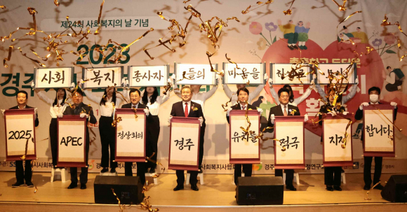 2023 경주시사회복지사대회에서  주요내빈 8명과 사회복지 종사자 7명이 APEC 정상회의 경주유치를 지지하는 퍼포먼스를 펼치고 있다.