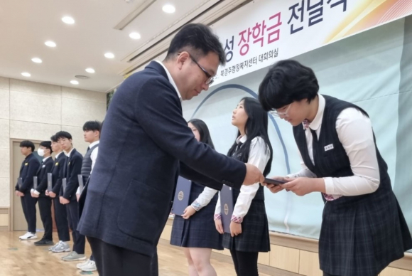 서정보 북경주행정복지센터장이 학생들에게 장학증서를 전달하고 있다.