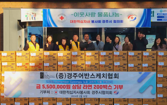 경주어반스케치협회가 지난 16일 황촌마을활력소 앞에서 대한적십자봉사회 경주시협의회에게 기부물품을 전달하고 기념촬영을 하고 있다.