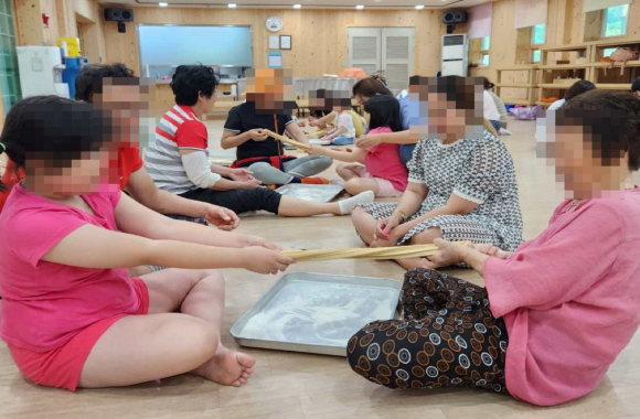 외국인 가족이 한국 문화체험 수업에 참여하고 있다.