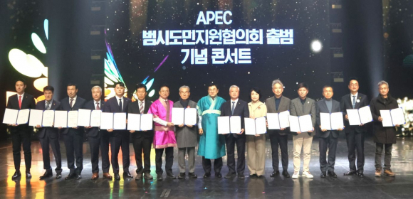 2025년 APEC 정상회의의 민간 협력 기반 강화를 위해 열린 ‘APEC 범시도민지원협의회 출범 기념 콘서트’에서 참석자들이 협력 결의문을 들고 기념촬영을 하고 있다.