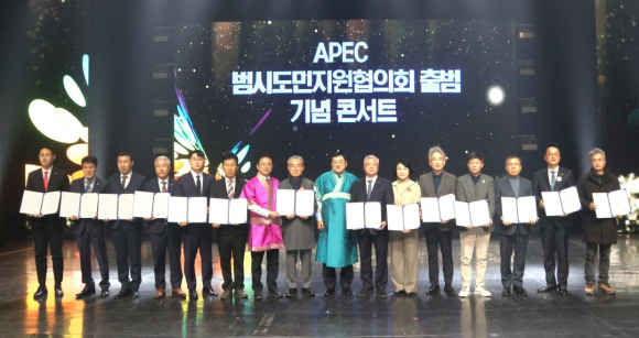 2025년 APEC 정상회의의 민간 협력 기반 강화를 위해 열린 ‘APEC 범시도민지원협의회 출범 기념 콘서트’에서 참석자들이 협력 결의문을 들고 기념촬영을 하고 있다.