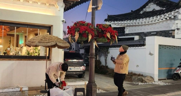 경주시가 황리단길 일원 가로등에 포인세티아 화분을 설치하며 겨울철 거리 경관을 정비하고 있다.