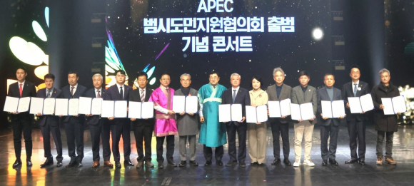 2025년 APEC 정상회의의 민간 협력 기반 강화를 위해 열린 ‘APEC 범시도민지원협의회 출범 기념 콘서트’에서 참석자들이 협력 결의문을 들고 기념촬영을 하고 있다.