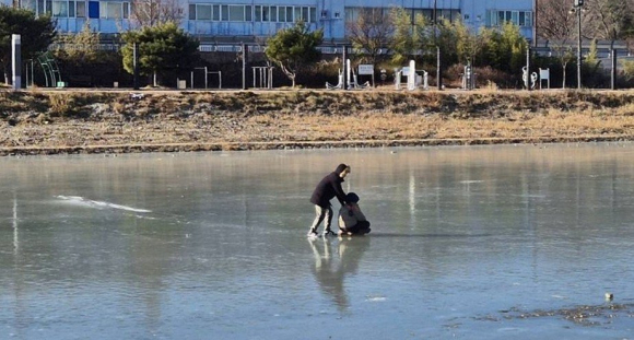 경주시 북천 하천 구간에서 얼음이 얼어붙은 가운데, 보호자와 함께 얼음 위에 진입한 어린이의 모습이 포착됐다.