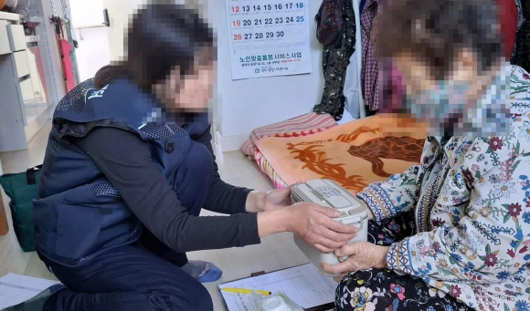 경주시 통합돌봄 식사지원 서비스 현장으로, 수행기관 관계자가 지역 어르신 가정을 방문해 반찬을 전달하며 건강 상태와 안부를 확인하고 있다.