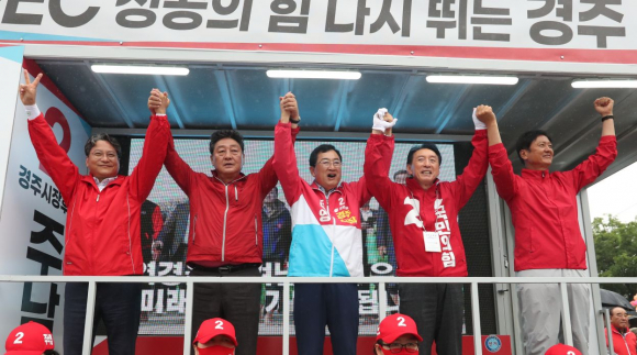 주낙영 경주시장 후보가 출정식에서 김석기 의원, 도의원 후보들과 인사를 하고 있다.