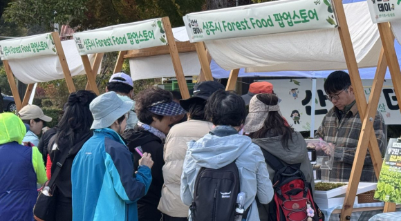 상주 트레킹을 마친 수도권 참가자들이 지역 먹거리를 체험하고 구입하고 있다.<자료사진>