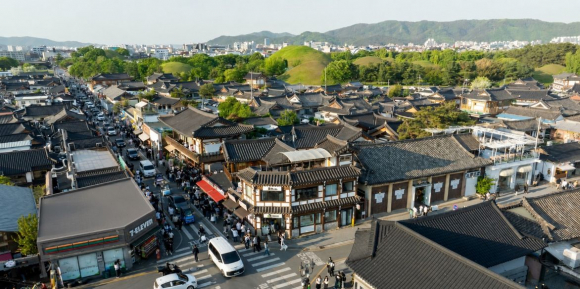 관광객들이 경주 황리단길 일원에서 한옥 거리와 대릉원을 배경으로 관광을 즐기고 있다.