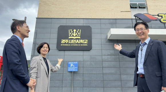 경주시민AI학교 현판 앞에서 기념촬영을 하고 있다.