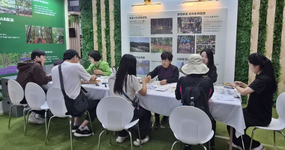 2026 경상북도 산림박람회 경주시 홍보부스에서 방문객들이 목공 체험 프로그램에 참여하고 있다.